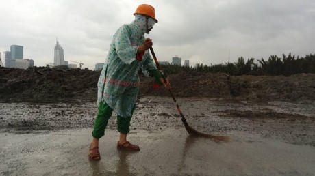 Nhân viên Công ty Công trình đô thị quận 2 dọn dẹp bùn thải vương vãi trên mặt đường, cống rãnh - Ảnh Quang Huy