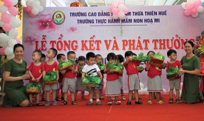 Cô Hồ Thị Thanh Hương - Hiệu trưởng trường Thực hành Mầm non Họa Mi (bên trái) trao tặng các phần quà cho các cháu trong buổi lễ tổng kết năm học 2017- 2018