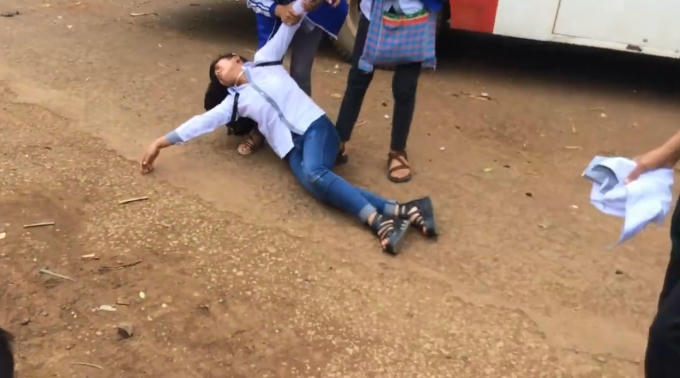 Nữ sinh choáng váng, bất tỉnh sau đòn đánh của nam sinh được bạn dìu dậy.