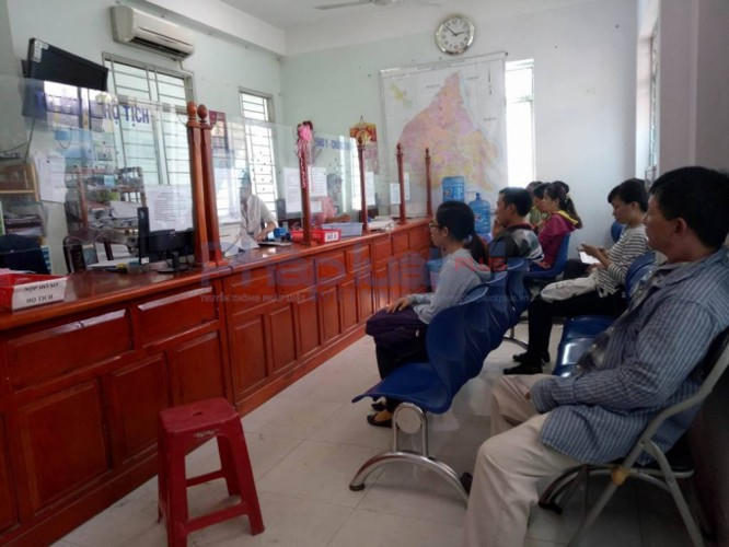 Người dân phải xếp hàng ngồi đợi làm việc.
