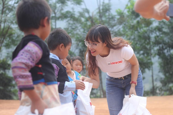 Phóng viên Nguyễn Huyên tặng quà cho các em nhỏ trong một chuyến đi tình nguyện tại Vân Hồ, Sơn La vào cuối năm 2017. Ảnh: NVCC