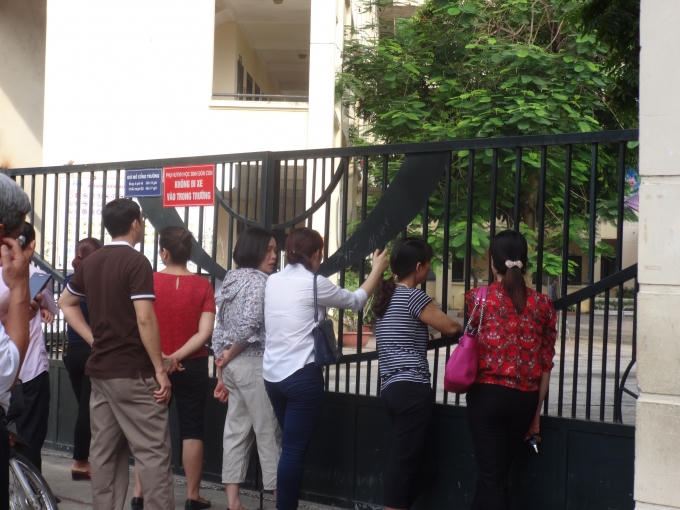 Dù con đã vào phòng thi, nhưng nhiều phụ huynh vẫn đứng chờ, cố gắng nhìn qua cánh cửa đế tìm đến phòng thi của con.