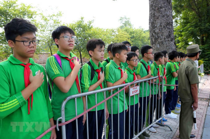 Các em học sinh trường THCS Nguyễn Tri Phương đưa tiễn linh cữu nguyên Tổng Bí thư Đỗ Mười trên phố Hoàng Diệu (Hà Nội). (Ảnh: Thành Đạt/TTXVN).