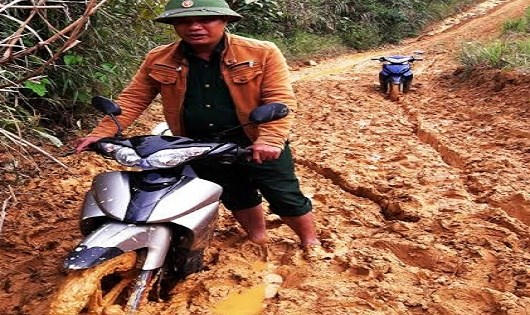 Thiếu t&aacute; L&ecirc; Văn Thắng dắt xe qua b&ugrave;n lầy.