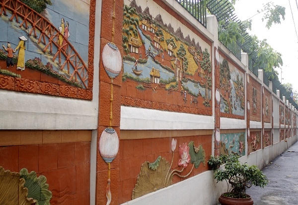Hình ảnh những bức tranh gốm được gắn trên bức tường dài hơn 200 mét đã tạo nên vẻ đẹp và sự bắt bắt cho mỗi ai đi ngang qua.