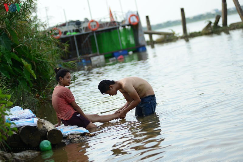 Nhiều đôi bạn trẻ cũng dẫn nhau ra sông Hồng nghịch nước để giảm nắng nóng.
