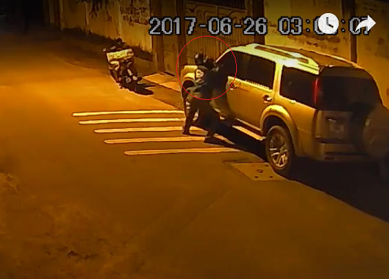 Hình ảnh nam thanh niên bẻ gương ô tô trong đêm.