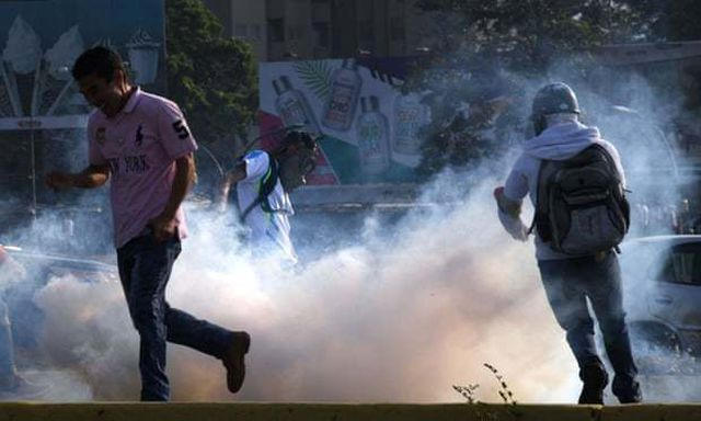 Người biểu tình đụng độ với lực lượng an ninh ở Caracas. (Ảnh: AFP)