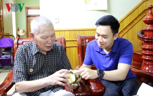 Ông Nguyễn Văn Ký kể cho con cháu nghe về chiếc ca kỷ vật thời Thanh niên xung phong.