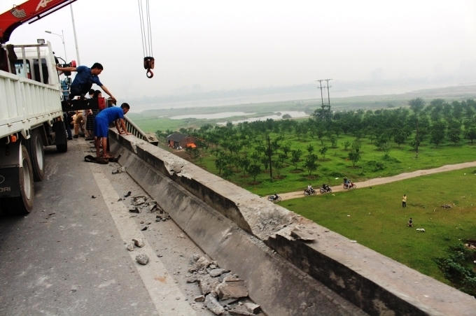 Chiếc xe tải phá nát hàng chục mét lan can cầu Vĩnh Tuy (Ảnh: Văn Lịnh).