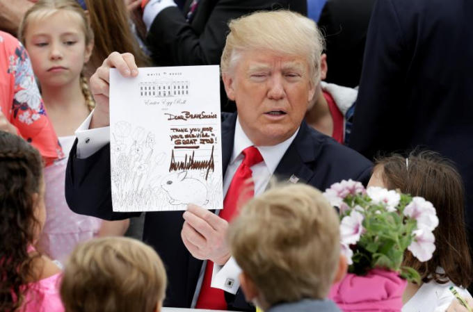 Tổng thống Trump cầm trên tay tấm thiệp chúc mừng lễ Phục sinh. Tấm thiệp này sẽ được gửi tới một thành viên trong quân đội Mỹ.