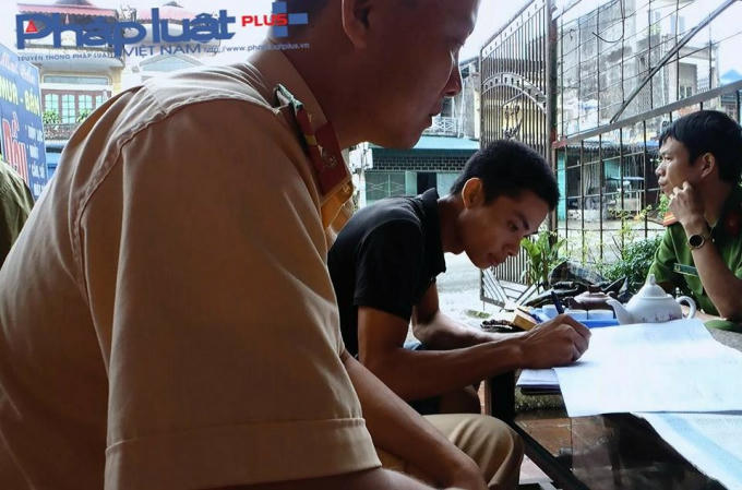 Tài xế Đoàn Văn Tuấn đang ký biên bản tại hiện trường (Ảnh: Tiến Vũ)