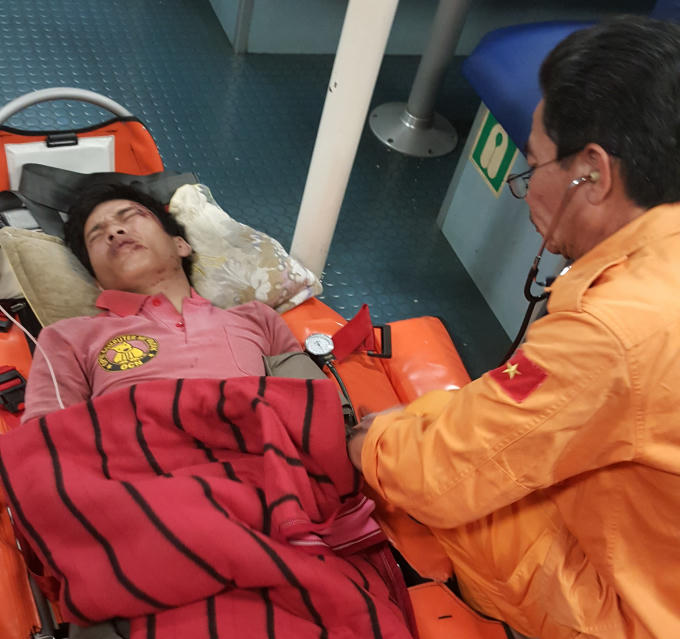 Thuyền viên Cát (trái) được cấp cứu sau khi gặp tai nạn lao động.