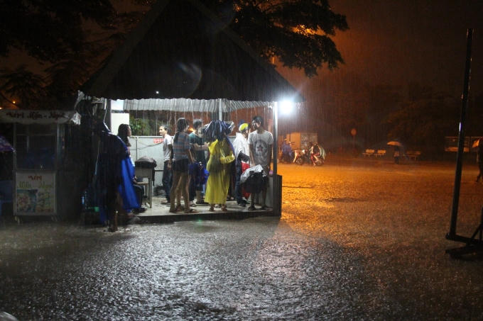 Một số bạn sinh viên muốn đi ra ngoài nhưng do mưa lớn nên đành mượn cổng bảo vệ để trú mưa.