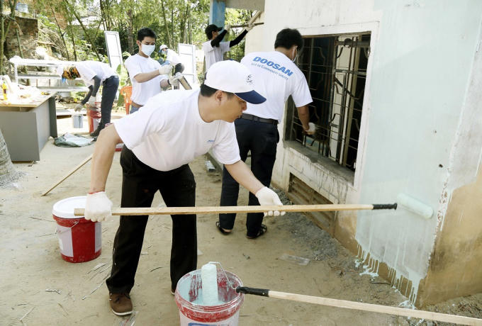 Các tình nguyện viên sơn lại căn nhà bị hư hỏng của người dân tại Quảng Ngãi.