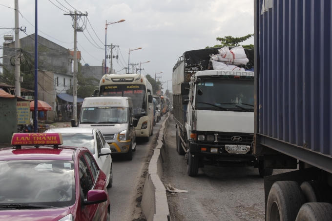 D&ograve;ng xe tải, xe &ocirc; t&ocirc;, xe container xếp h&agrave;ng k&eacute;o d&agrave;i từ s&aacute;ng tới tối do mặt đường qu&aacute; xấu.