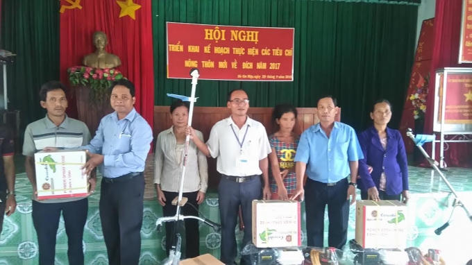 Các hộ đồng bào dân tộc thiểu số nghèo nhận công cụ và nông cụ sản xuất.