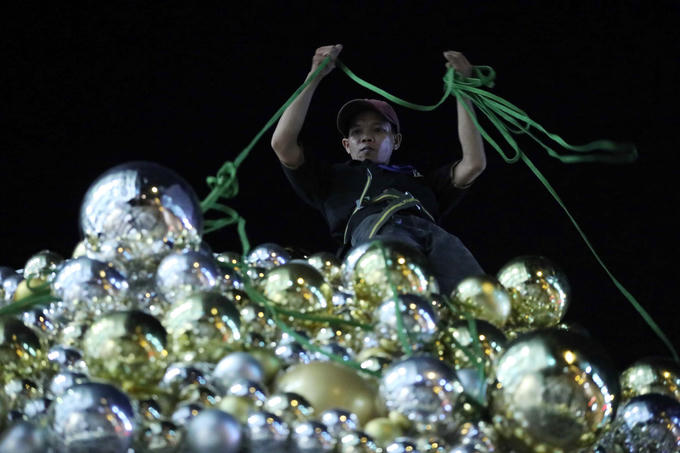 Anh Lê Thanh Hoài đang lắp các trái châu cho cây thông Noel trước trung tâm thương mại ở quận 1. Anh cho biết, cứ cuối tháng 11 đến giữa tháng 12 mỗi năm, công việc của anh lại tất bật khi được nhiều tòa nhà thuê trang trí Noel. "Công việc của tôi chủ yếu làm về đêm, bắt đầu từ 22h đến sáng vì khi đó các trung tâm thương mại đóng cửa, ít người qua lại", anh chia sẻ và cho biết đã gắn bó với công việc này hơn 10 năm.