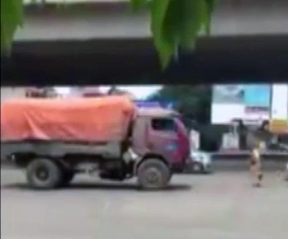 CSGT chạy bộ đuổi theo xe tải lùi ngược chiều. (Ảnh cắt từ clip)