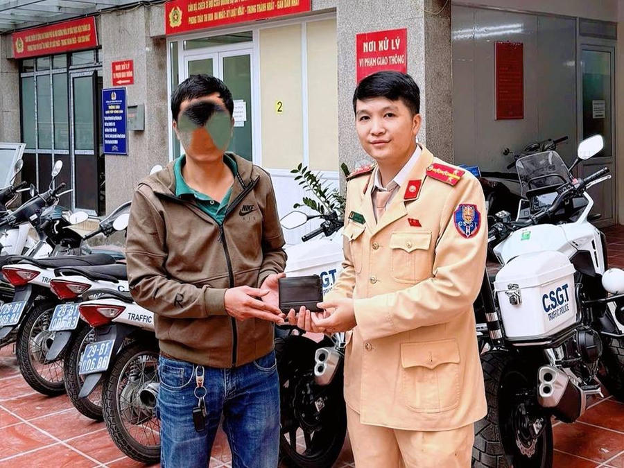 Anh Lê Viết T nhận lại tài sản thất lạc từ CSGT. Ảnh: Công an Hà Nội.