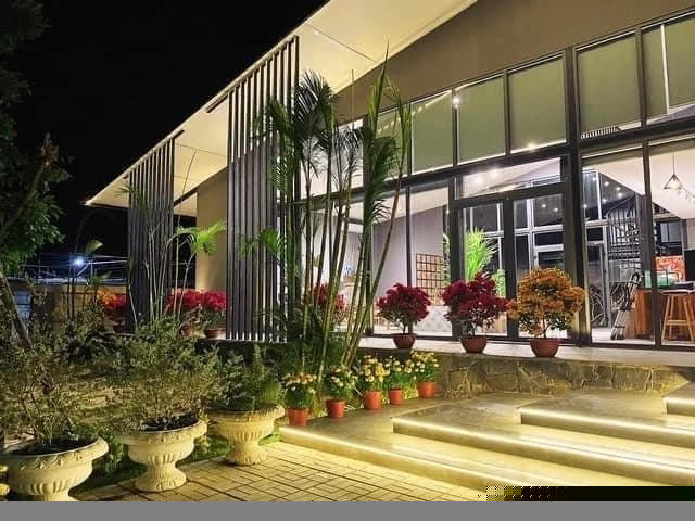 Biệt thự có không gian mở, với nhiều cửa kính cường lực. Phần cửa kính anh dán phim cách nhiệt cản nắng. Bậc thềm gia chủ trang trí bằng nhiều chậu hoa cảnh, còn ngoài vườn trồng cỏ Nhật và các loại hoa dễ chăm.