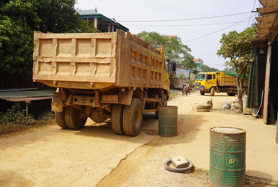 Dân mang thùng phuy, khúc gỗ... chặn đoàn xe tải chở đất - Ảnh 2.