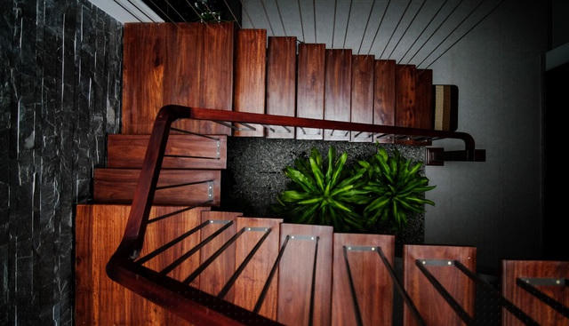 Cầu thang được làm từ khung dầm thép hộp, mặt gỗ tự nhiên và trang trí thanh treo bằng inox đặc.