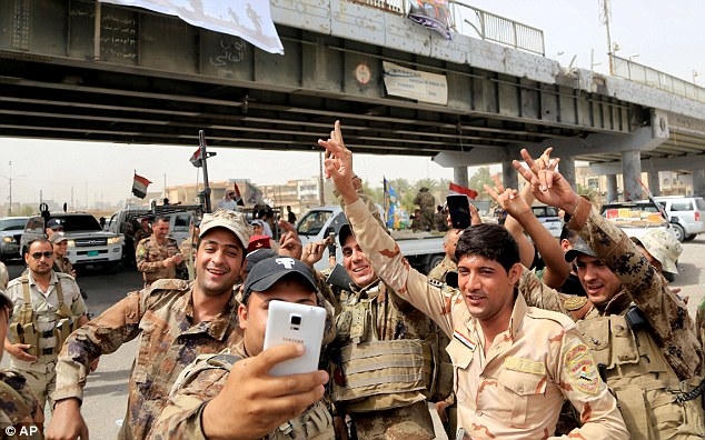 Lực lượng quân đội Iraq chụp ảnh ăn mừng chiến thắng. (Ảnh: AP)