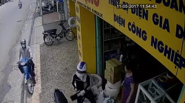 Phát hiện sơ hở của người phụ nữ, tên cướp lái xe lượn qua chờ cơ hội ra tay.