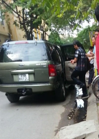 Nghi phạm được áp giải lên chiếc xe ô tô đỗ cạnh hiện trường (Ảnh: Hà Khê).