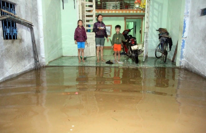 Nước lũ tràn vào nhà dân, tài sản được thu dọn lên cao.