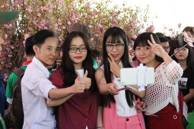 Ngoài việc tham quan, chiêm ngưỡng nét đẹp của hoa anh đào thì việc chụp ảnh kỉ niệm với các bạn trẻ là một điều vô cùng thích thú.