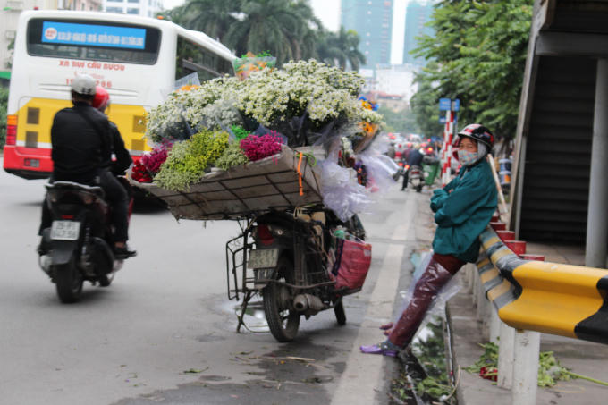 Những người bán hàng rong mặc nhiều loại áo để chống lại cái lạnh đầu mùa trên đường Nguyễn Chí Thanh.