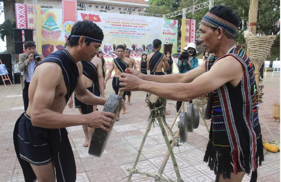 Nghệ nhân Ưu tú K'Brel thực hiện nghi thức trao chiêng vào hội. Ảnh: Báo Lâm Đồng
