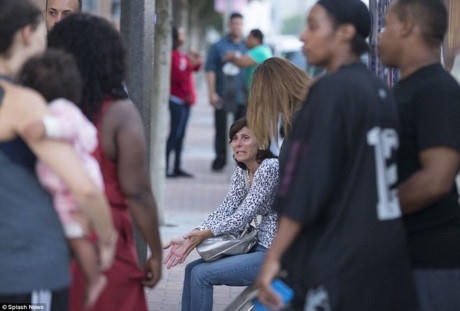 Một phụ nữ đang khóc khi ngồi chờ tin người thân bên ngoài hộp đêm sau vụ xả súng. Ảnh: Splash News