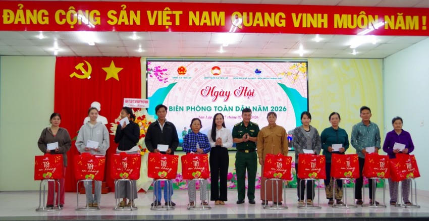Lãnh đạo Đồn Biên phòng CK Chàng Riệc và lãnh đạo xã Tân Lập trao quà cho các hộ dân
