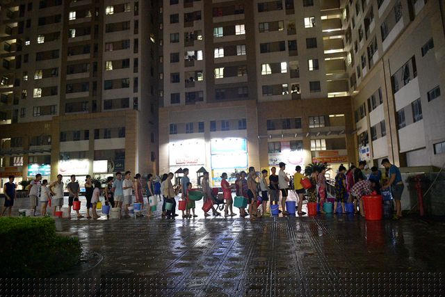 Càng về tối lượng người xếp hàng chờ múc nước tại bể ngầm càng đông.