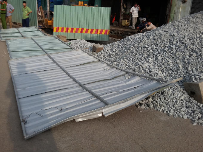 Tôn rào chắn của công trình đổ ra đường.