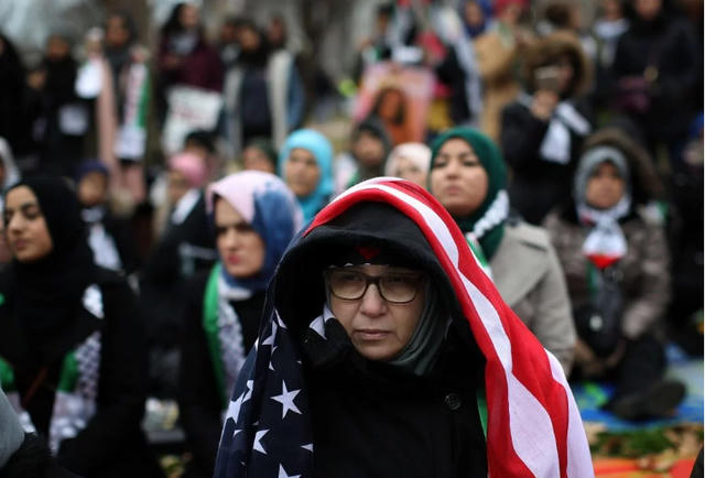 Đội khăn choàng keffiyeh truyền thống của Palestine và khăn mang màu cờ của Palestine, những người biểu tình mang theo áp phích phản đối việc Israel chiếm đóng khu vực Đông Jerusalem và Bờ Tây. (Ảnh: Getty)