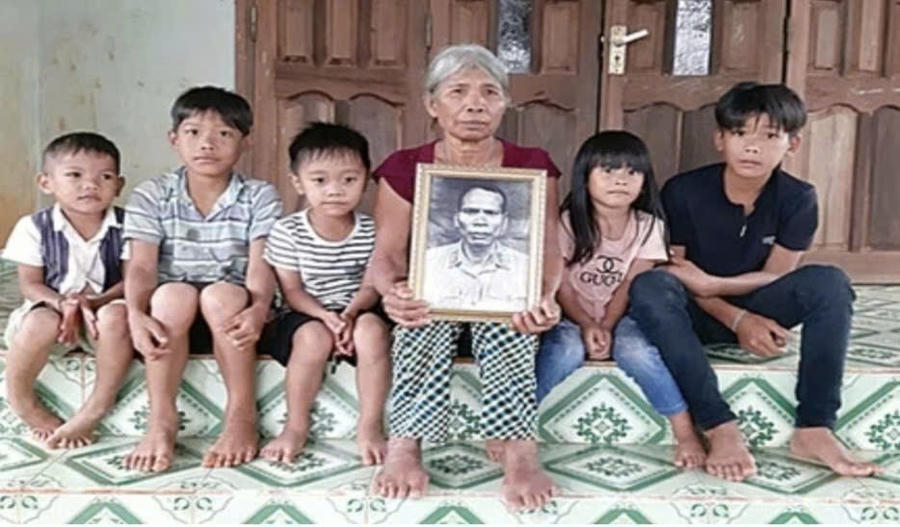 Bà Siu Pil ( vợ ông A Sanh) và các cháu bên di ảnh của ông A Sanh. Ảnh: Nguyễn Quang Tuệ