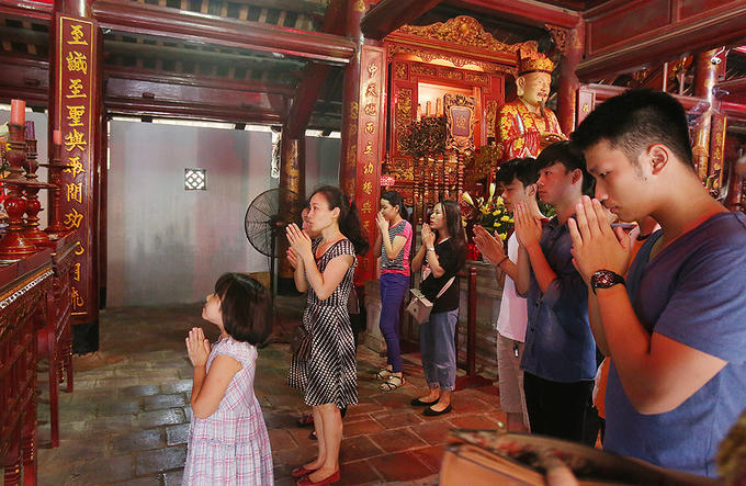 Phía trong chính điện, từng tốp sĩ tử và người nhà thành kính dâng hương.