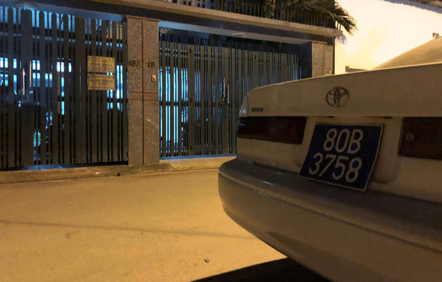 Sau đó cánh cổng sắt đóng lại trong khi chiếc xe biển số xanh đậu ven đường.