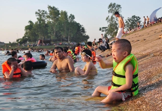 Cháu nhỏ ngồi khóc một mình vì bố mẹ, anh chị được ra ngoài bơi (Ảnh: Vietnamnet.vn).