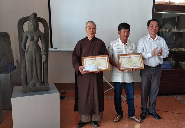 Phó Chủ tịch UBND tỉnh Vĩnh Long (phải) trao tặng Bằng khen và số tiền 75 triệu đồng cho hai cá nhân phát hiện và tự nguyện giao nộp tượng nữ thần.