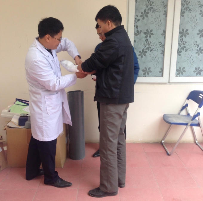 Bác sĩ băng bó lại vết thương cho Nguyễn Đoàn Bộ sau khi giám định pháp y thương tích tại Trung tâm Pháp y - Sở Y tế Hà Nội.