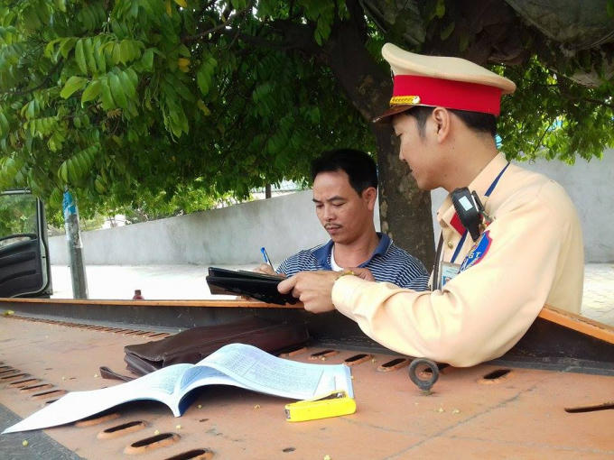 Cán bộ Đội CSGT số 6 đang tiến hành kiểm tra giấy tờ của lái xe.