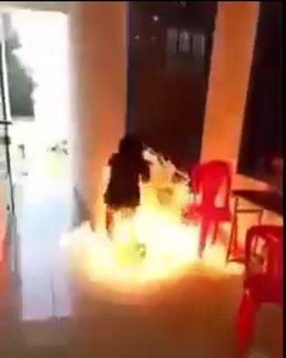 Cô gái đổ xăng đốt trường. (Ảnh cắt từ clip. Nguồn: Facebook).
