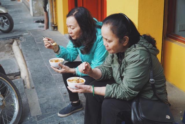Giữa phố thị phồn hoa, nhiều người đã dừng chân lại trên vỉa hè để thưởng thức một món ăn dân dã