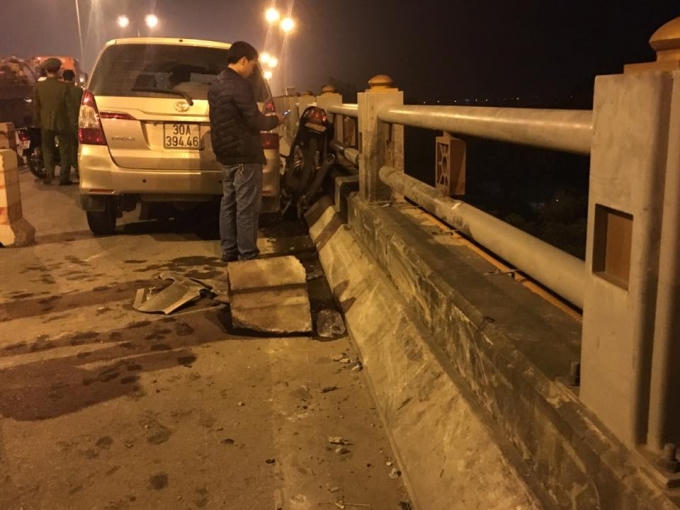 Chiếc xe máy bị ép sát vào thành cầu Thanh Trì. (Ảnh: Đ.N).