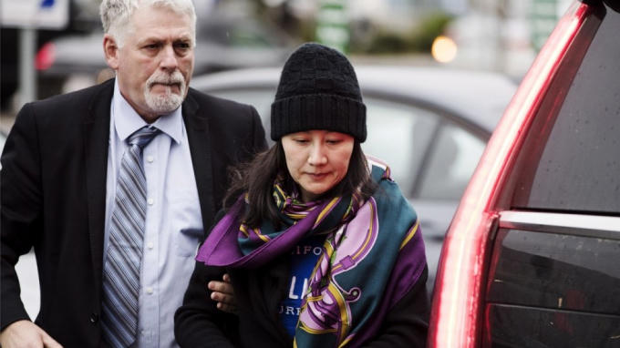 Nhân viên an ninh Canada kèm sát bà Mạnh Vãn Chu sau khi bà được bảo lãnh tại ngoại. Ảnh: AP.